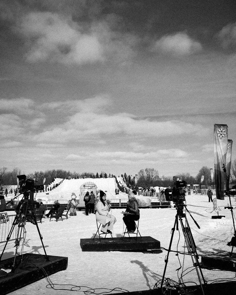 Victoria Williston interviewed by Julie Findlay of Rogers tv's Ottawa in the Know at Winterlude, seated on a small stage in the snow between two television cameras